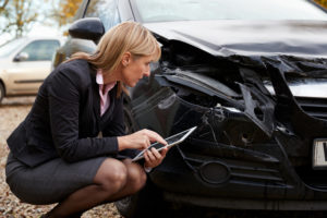 insurance adjuster looking at car that was in accident