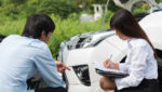 insurance adjuster reviewing car accident damage with claimant