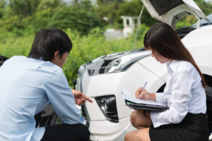 insurance adjuster reviewing car accident damage with claimant