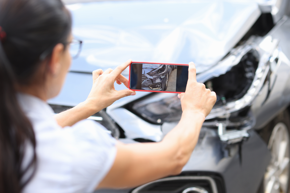 insurance adjuster taking photos of car accident
